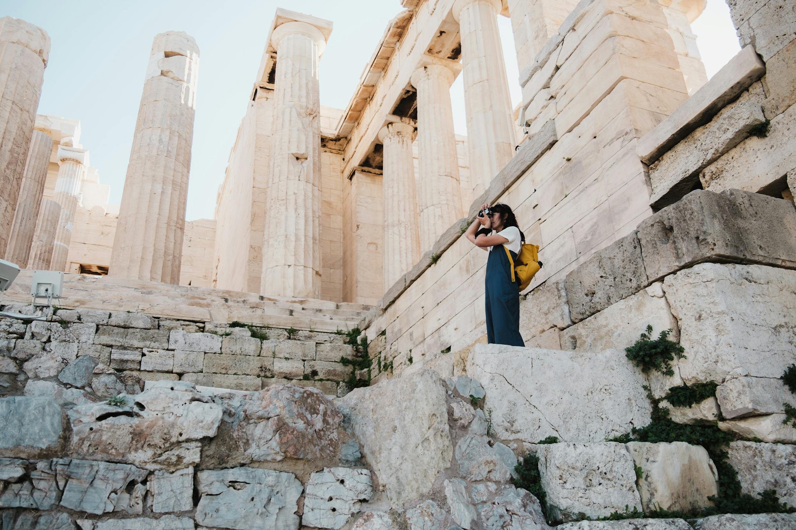 A woman taking pictures at the historic Parthenon ruins in Athens, Greece.