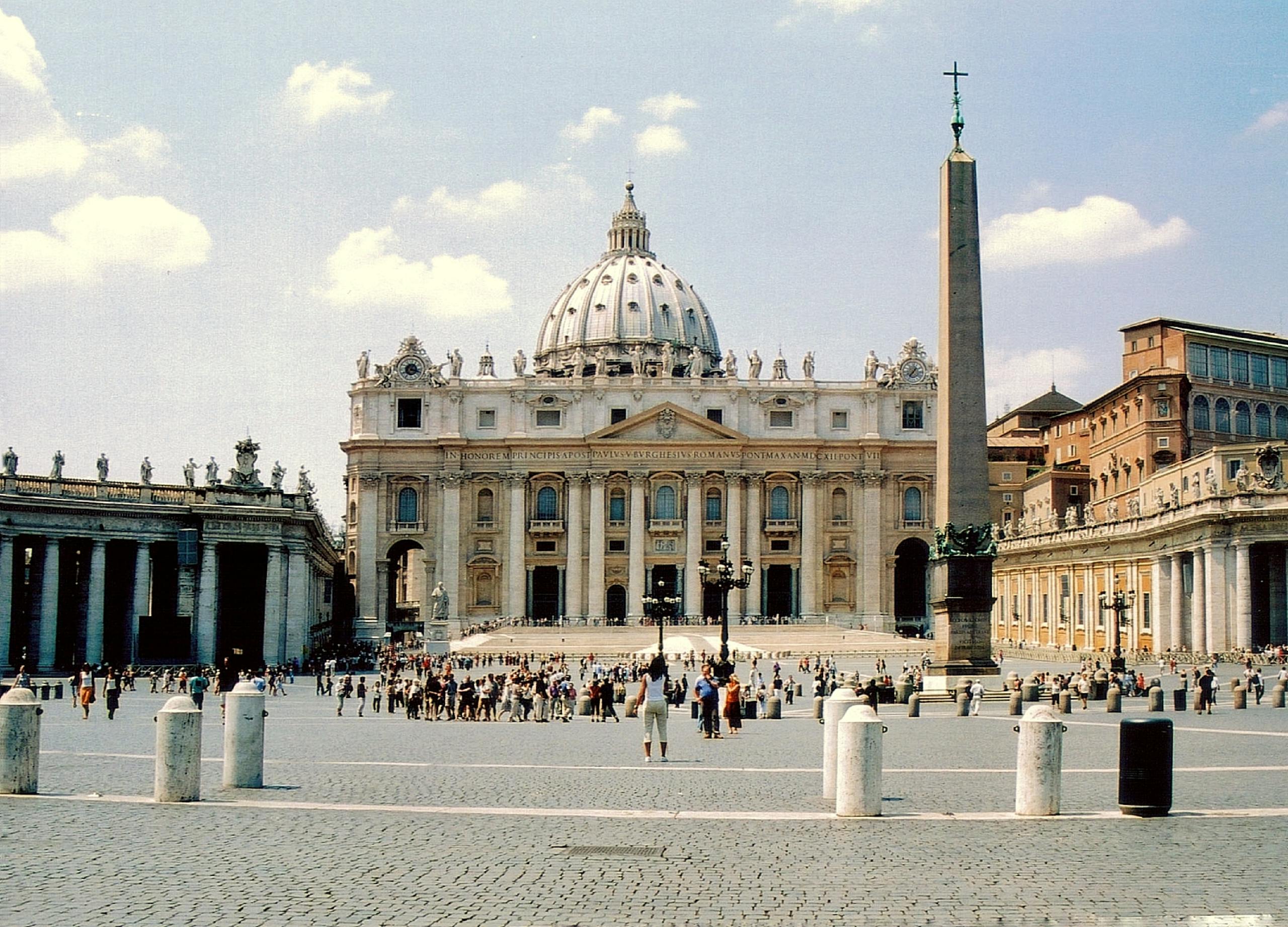 St. Peter's Basilica facade in Vatican City, a famous landmark bustling with tourists.