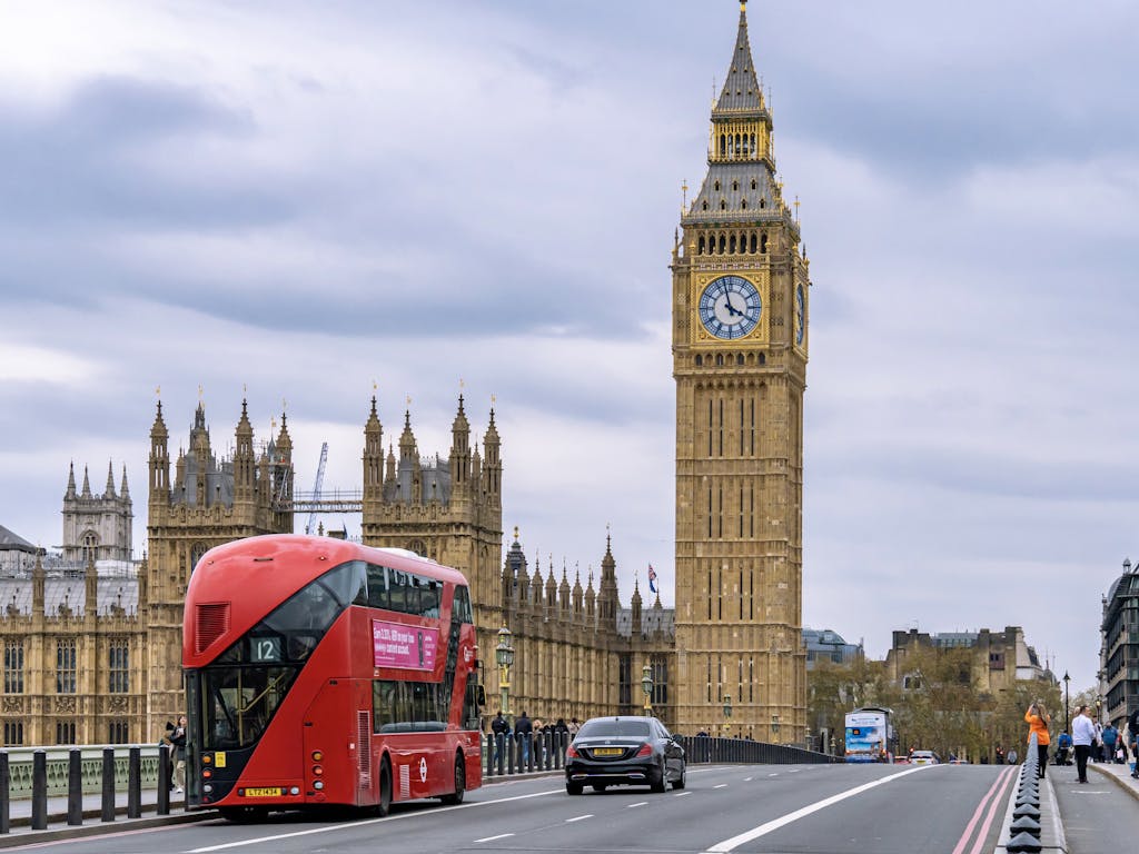 View of Big Ben, the Palace of Westminster, and a red double-decker bus in London.